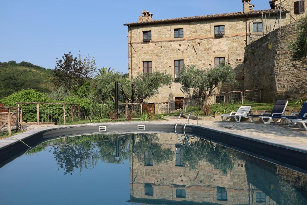 a swimming pool in front of a building at Cucina condivisione e natura - il rifugio perfetto per gruppi fino 31 - Assisi Perugia in Pianello