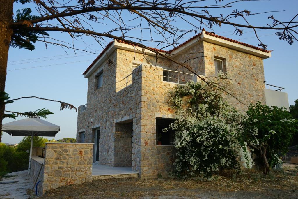 a stone house in the middle of a yard at Villa La Fontaine "Luxury apartment" in Porto Heli
