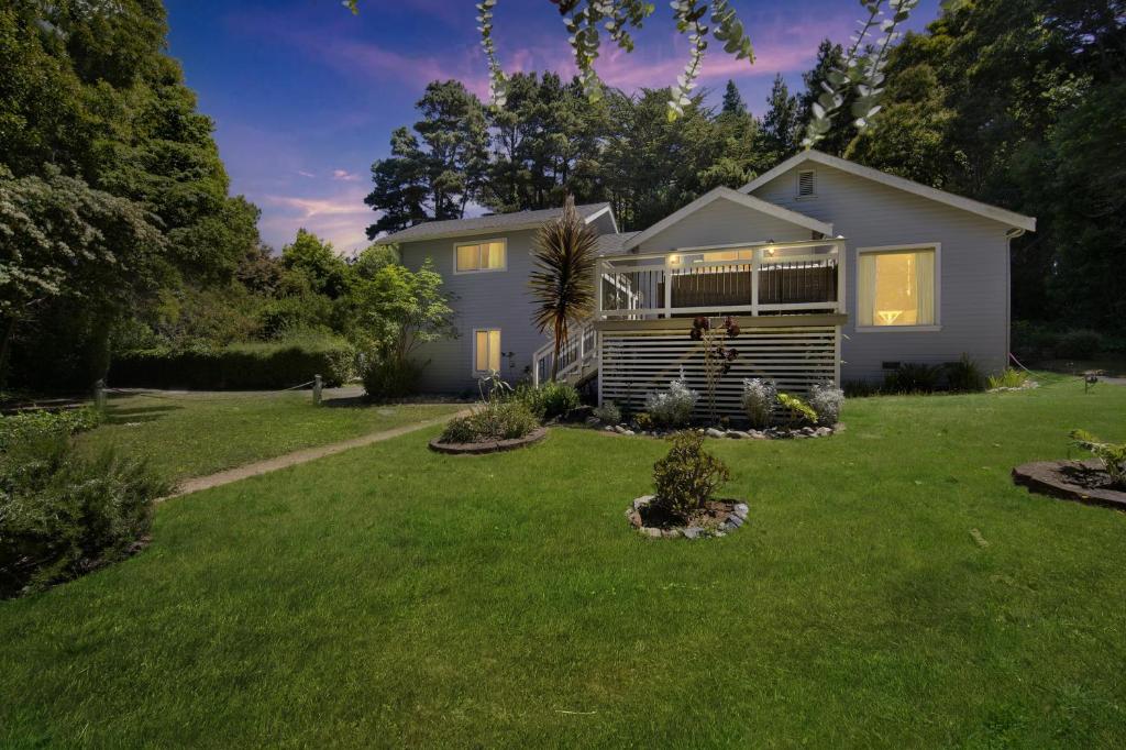 a house with a yard with green grass at Charming Pet Friendly Coastal Getaway home in Fort Bragg
