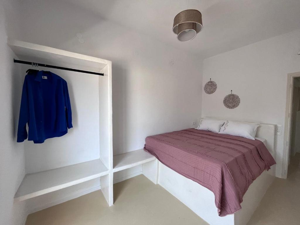 - une petite chambre avec un lit et une couverture violette dans l'établissement suite diminutif 2, à Adamas