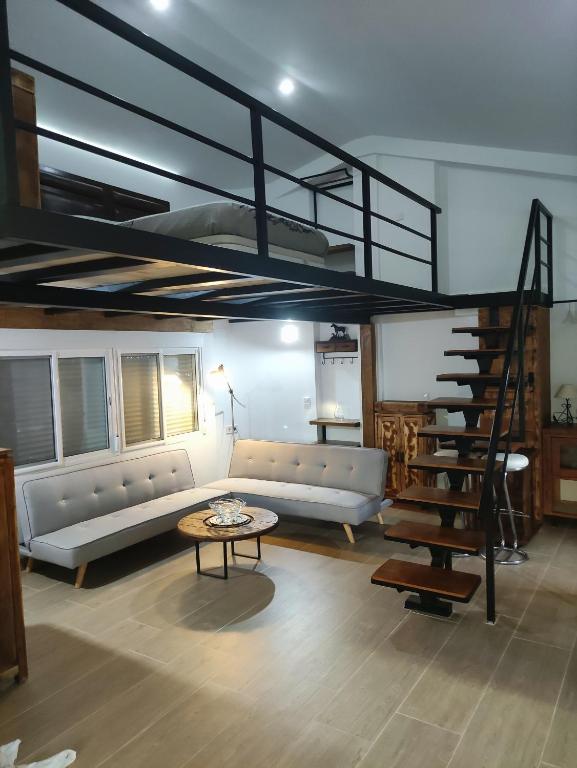 uma sala de estar com um sofá e uma escada em espiral em Loft de lujo calle de las marines em Denia