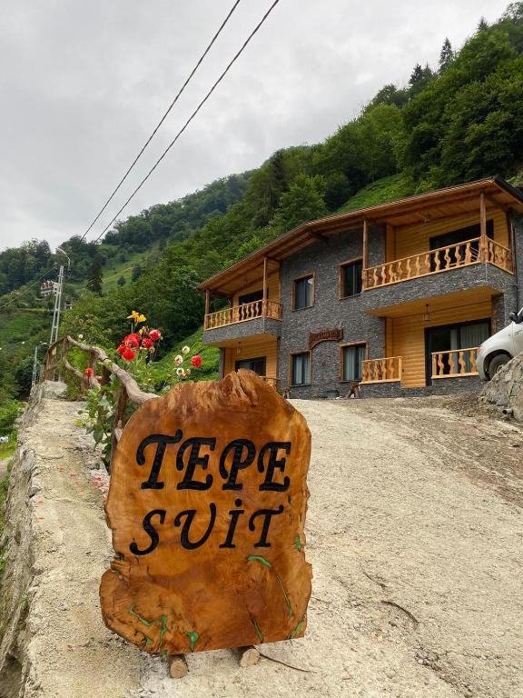 a log sign in front of a house at Tepe Dağ Evleri in Çamlıhemşin