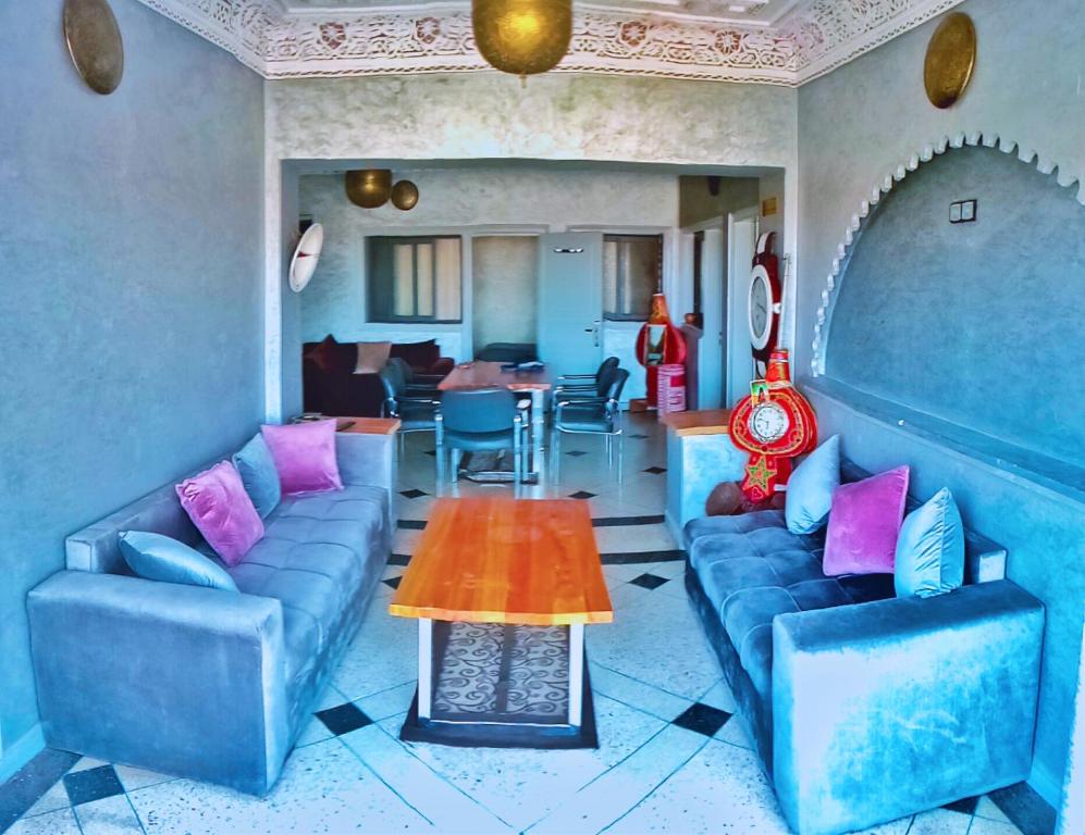 - un salon avec des canapés bleus et une table dans l'établissement Hotel Restaurant Bougafer, à Midelt