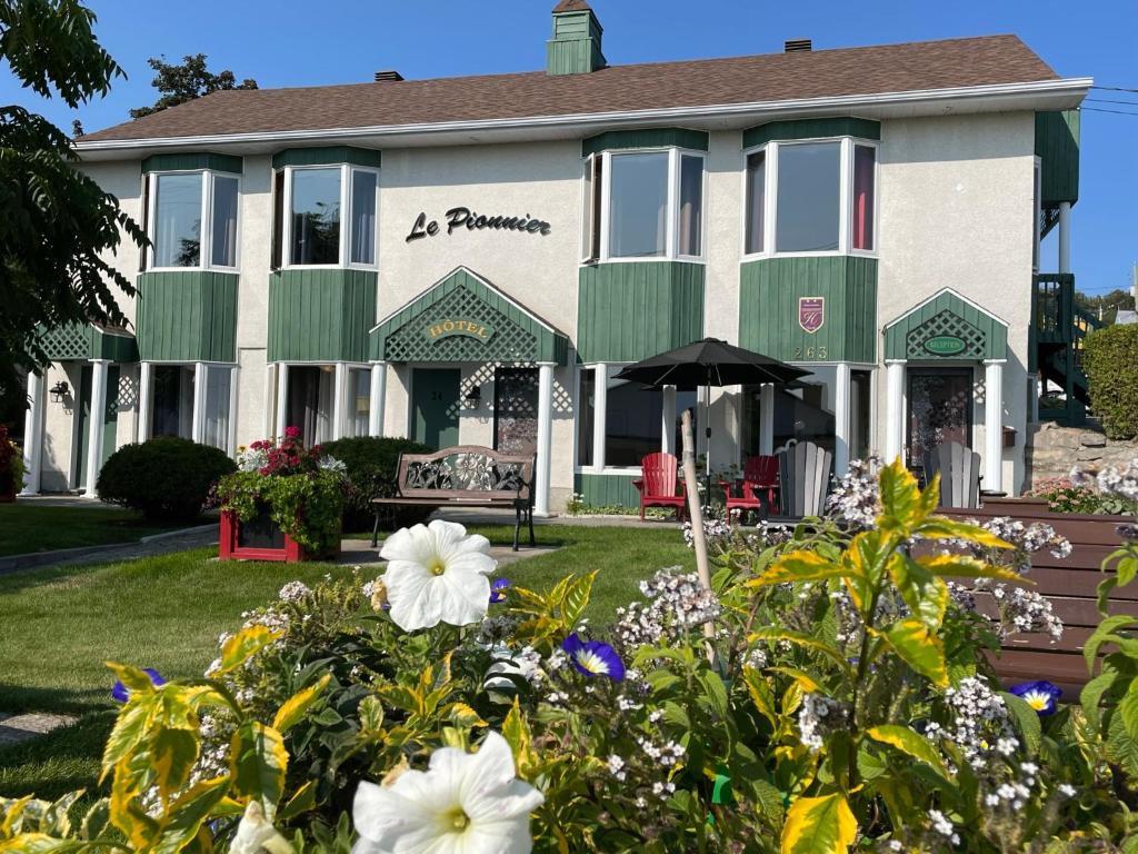 a building with flowers in front of it at Hotel Le Pionnier in Tadoussac