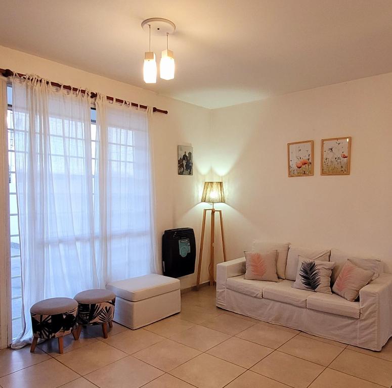 uma sala de estar com um sofá e uma mesa em "Valentino hostel" em Ezeiza