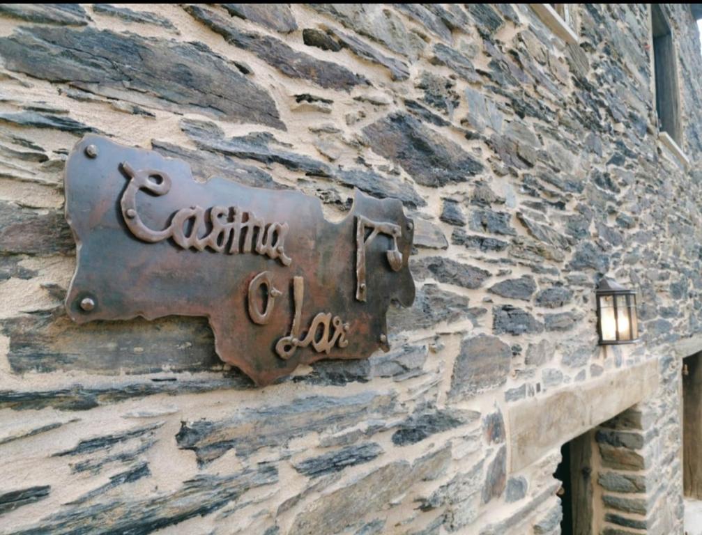 una señal de metal en el lateral de un edificio de piedra en Casina o Lar, 