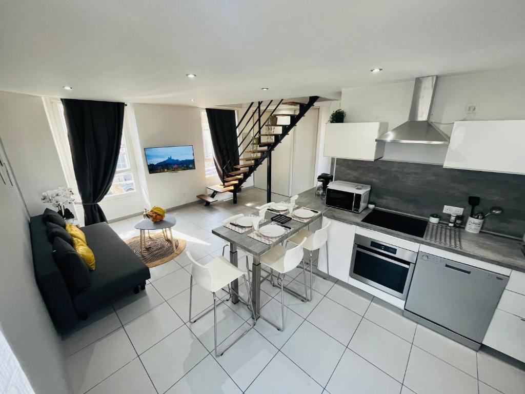 une cuisine et un salon avec un canapé et une table dans l'établissement SUPERBE DUPLEX DESIGN NEUF 2 CHAMBRES, CLIMATISE TOUT CONFORT, FACILE D,ACCES STATIONNEMENT GRATUIT, à Marseille