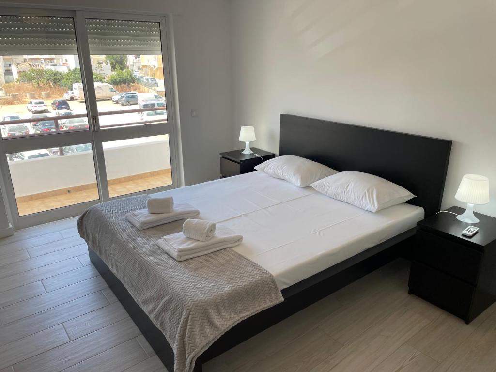 a bedroom with a large bed with two towels on it at A Minha Praia in Quarteira