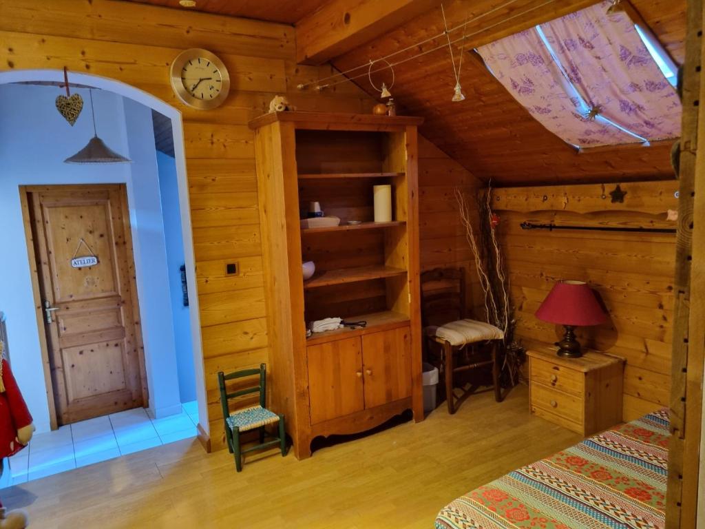 1 dormitorio con 1 cama y reloj en la pared en Comme à la maison, chambres au calme en Verrens-Arvey