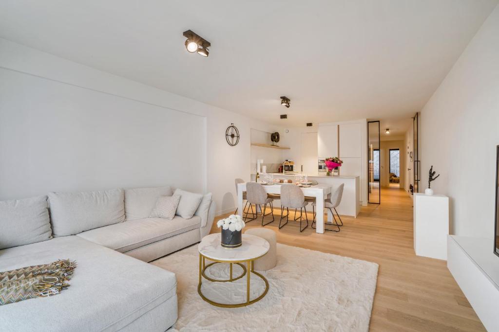 - un salon avec un canapé et une table dans l'établissement Modern appartement in hartje Oostende, à Ostende