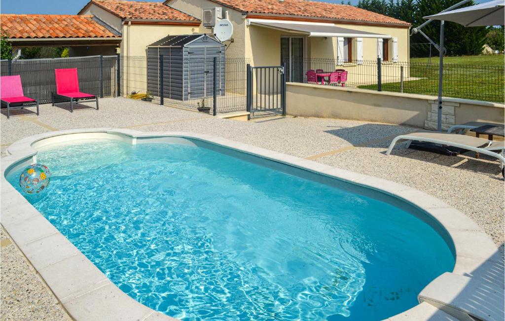 Blis-et-Born的住宿－Nice Home In Blis Et Born With Kitchenette，一个带粉红色椅子的大型蓝色游泳池以及一座房子