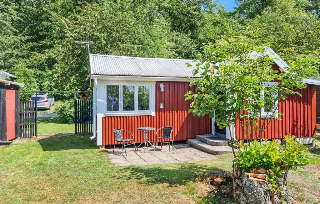 um barracão vermelho com cadeiras e uma mesa num quintal em Lovely Home In Slvesborg With Kitchen em Sölvesborg