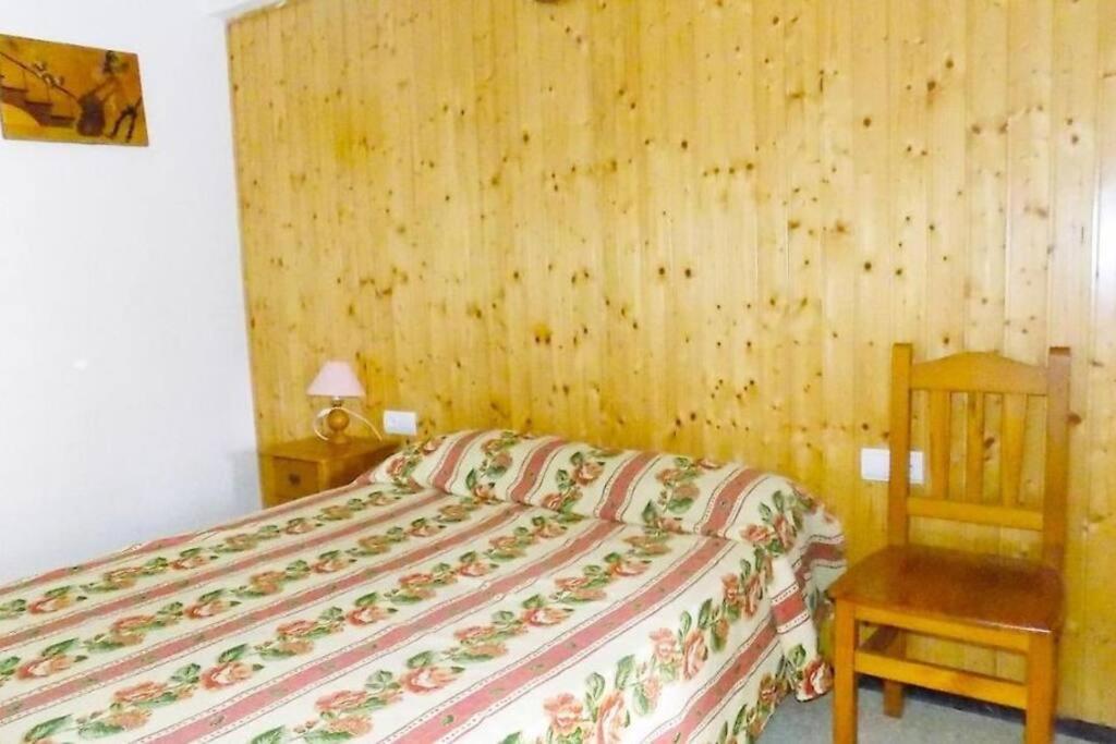 サロウにあるApartsalou Malvinasの木製の壁のベッドルーム1室(ベッド1台付)