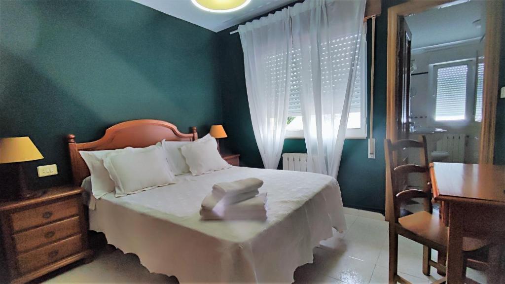 a bedroom with a bed and a table and a chair at Habitaciones CASA BRAIS in Barreiros