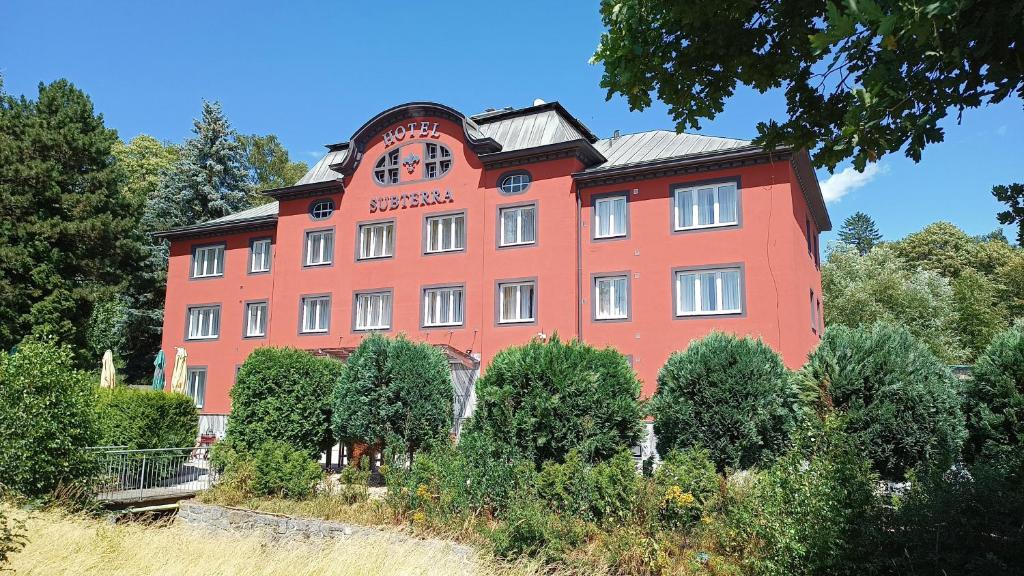 a large red building with a clock on it at Active & Wellness Hotel Subterra in Ostrov