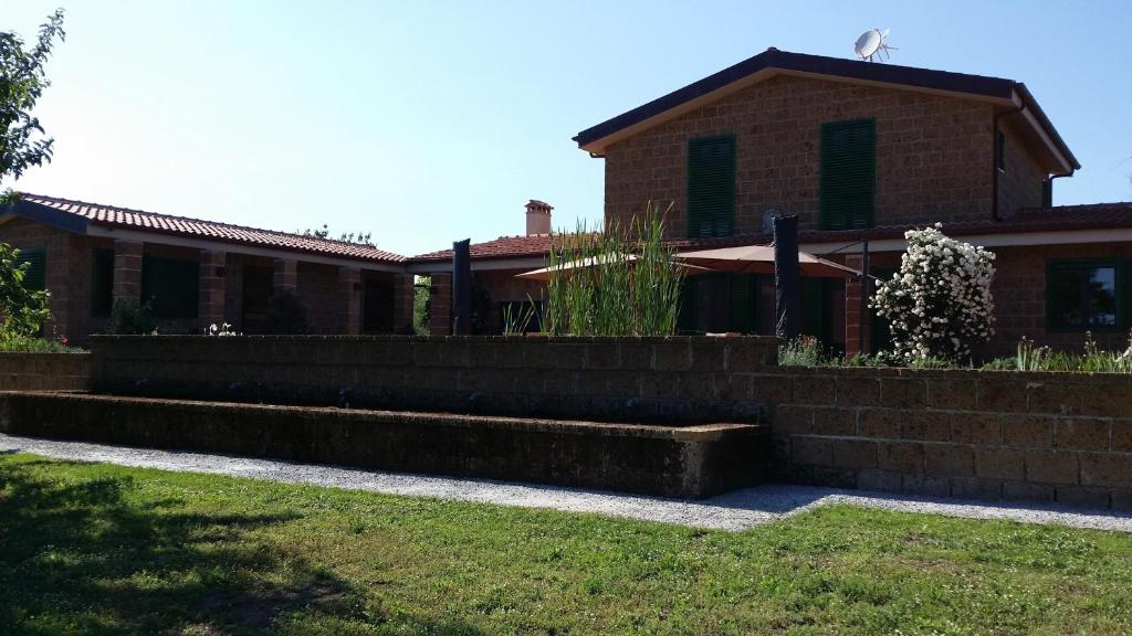 una casa de ladrillo con una pared de retención delante de ella en Il Giardino nell'Orto, en Vetralla