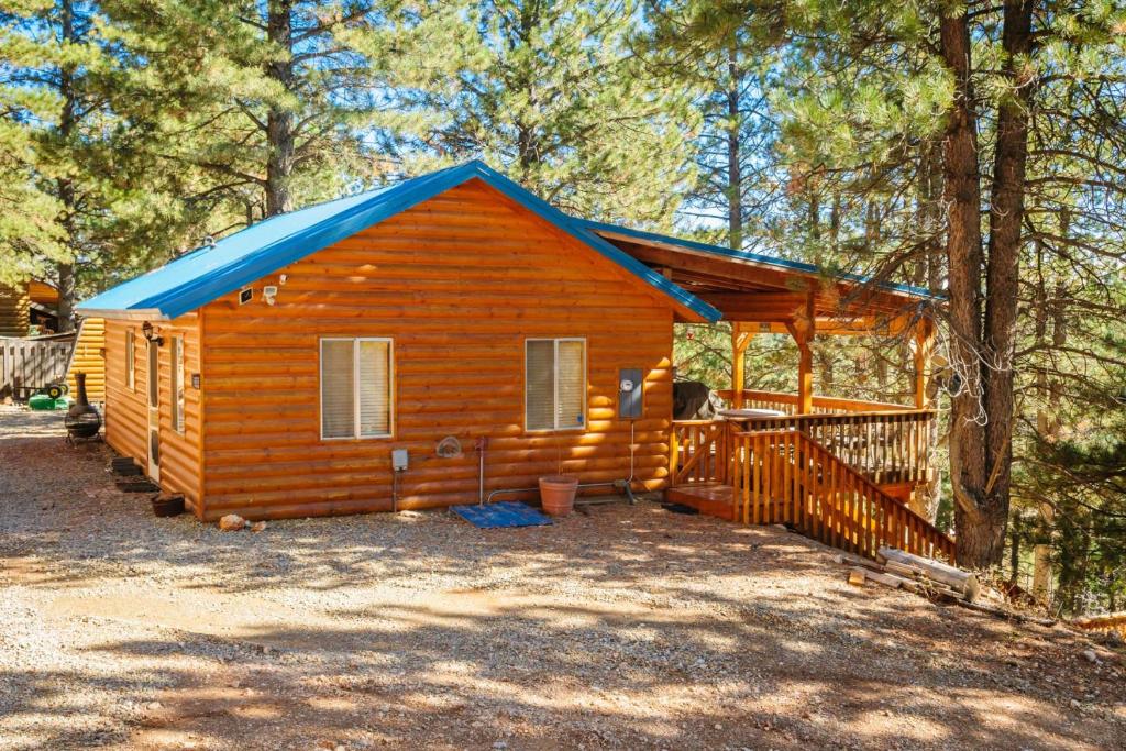 une cabine dans les bois avec un toit bleu dans l'établissement Strawberry Patch, à Duck Creek Village