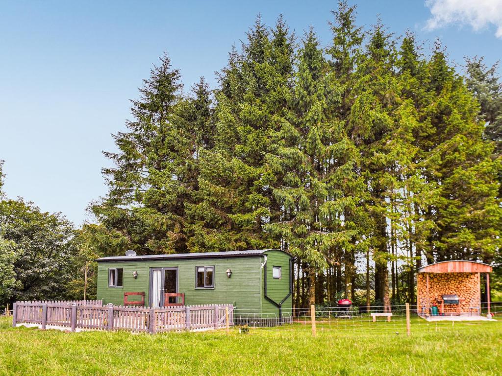 a green trailer in a field next to trees at Beverleys Hideaway - Uk44691 in Scorton