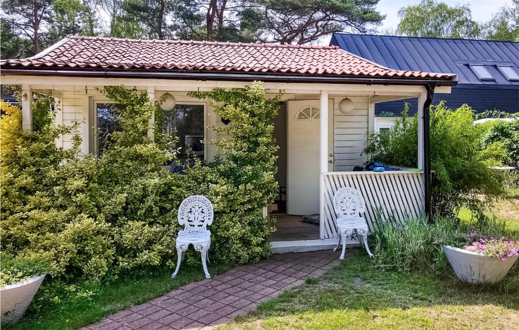 een klein huis met twee stoelen in de tuin bij 1 Bedroom Amazing Home In Hllviken in Höllviken
