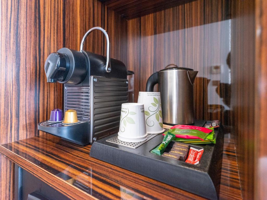 a counter with a coffee maker and cups on it at Westotel Le Pouliguen in Le Pouliguen