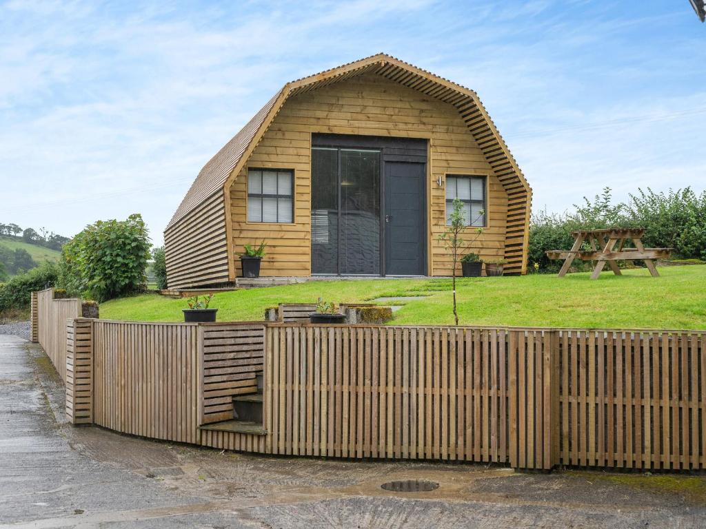 una casa pequeña con techo de paja en The Honey Pod - Uk44780 en Hoel-galed