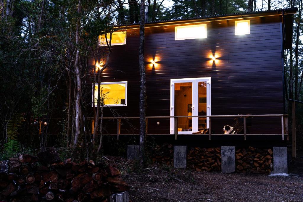 ein schwarzes winziges Haus im Wald nachts in der Unterkunft Travesía austral tinyhouse in Puerto Varas