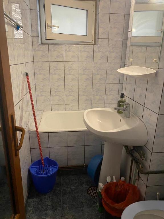 een badkamer met een wastafel, een toilet en een bad bij Apartament in Craiova