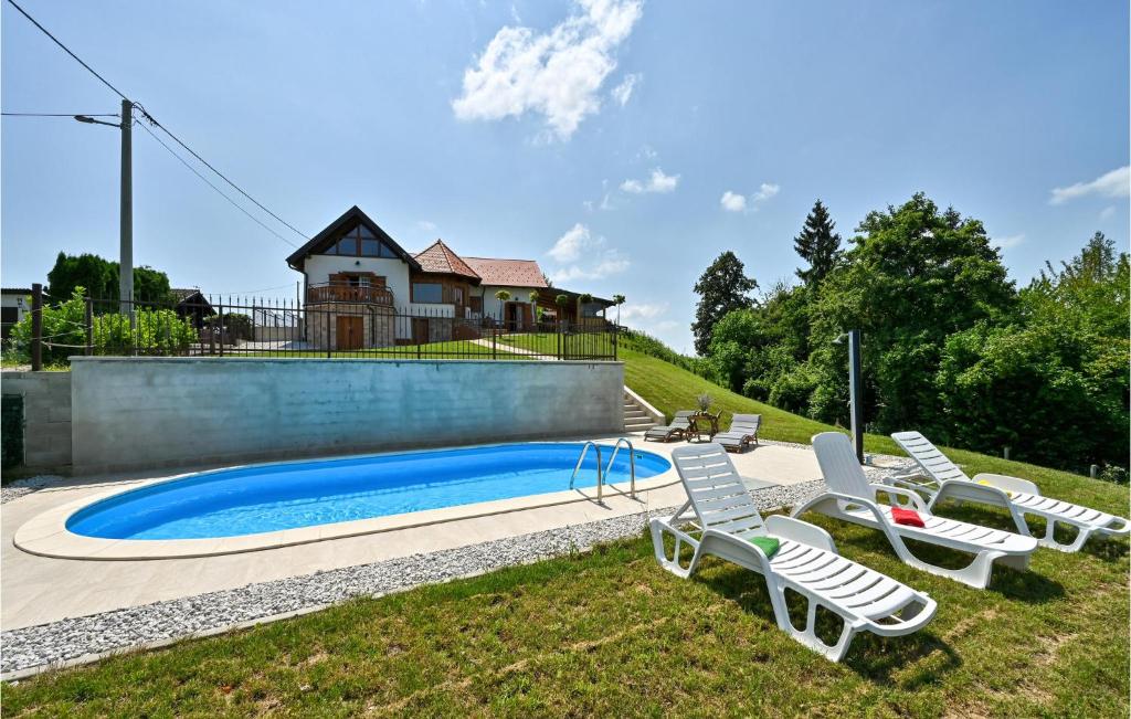 eine Gruppe von Liegestühlen neben einem Pool in der Unterkunft Lovely Home In Veliki Lovrecan With House A Panoramic View in Veliki Lovrečan