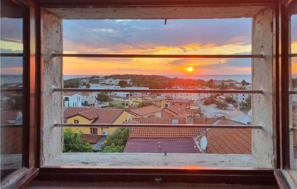 een open raam met uitzicht op de zonsondergang bij Nice Apartment In Funtana With Kitchen in Funtana