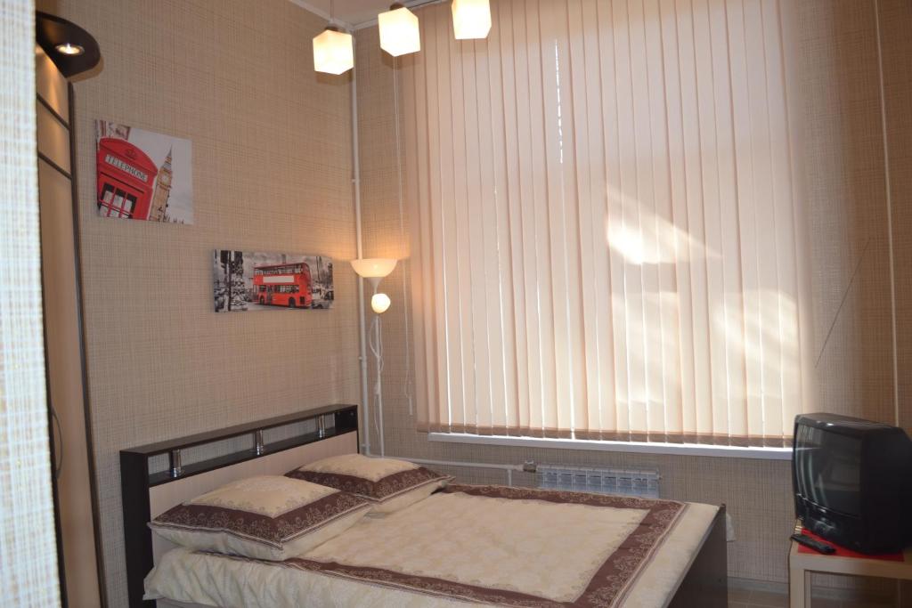 um pequeno quarto com uma cama e uma janela em Hotel Sagittarius em Samara