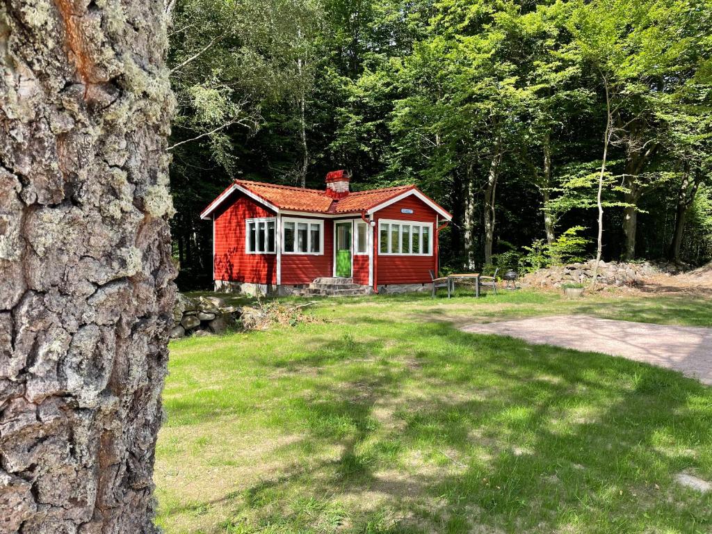 una cabina roja en medio de un patio en Ormanäs Stugby, en Höör