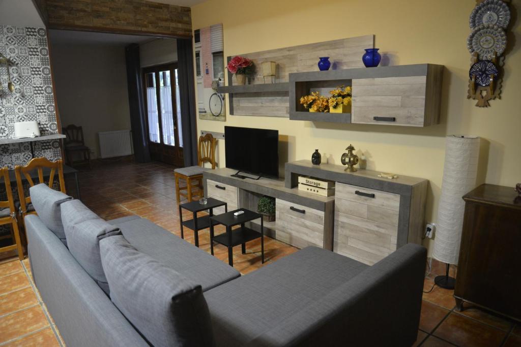 a living room with a couch and a television at La Pedriza in Galapagar