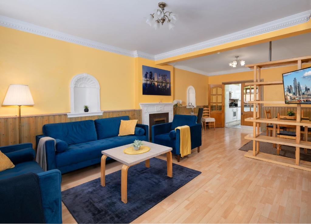 a living room with blue couches and a table at Excel 5min CUSTOM HOUSE STATION parking WIFI sleeps 6 in London