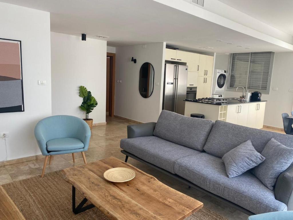 a living room with a couch and a table and a kitchen at Relax Sea View 3BR in Gordon Beach by Holyguest in Tel Aviv