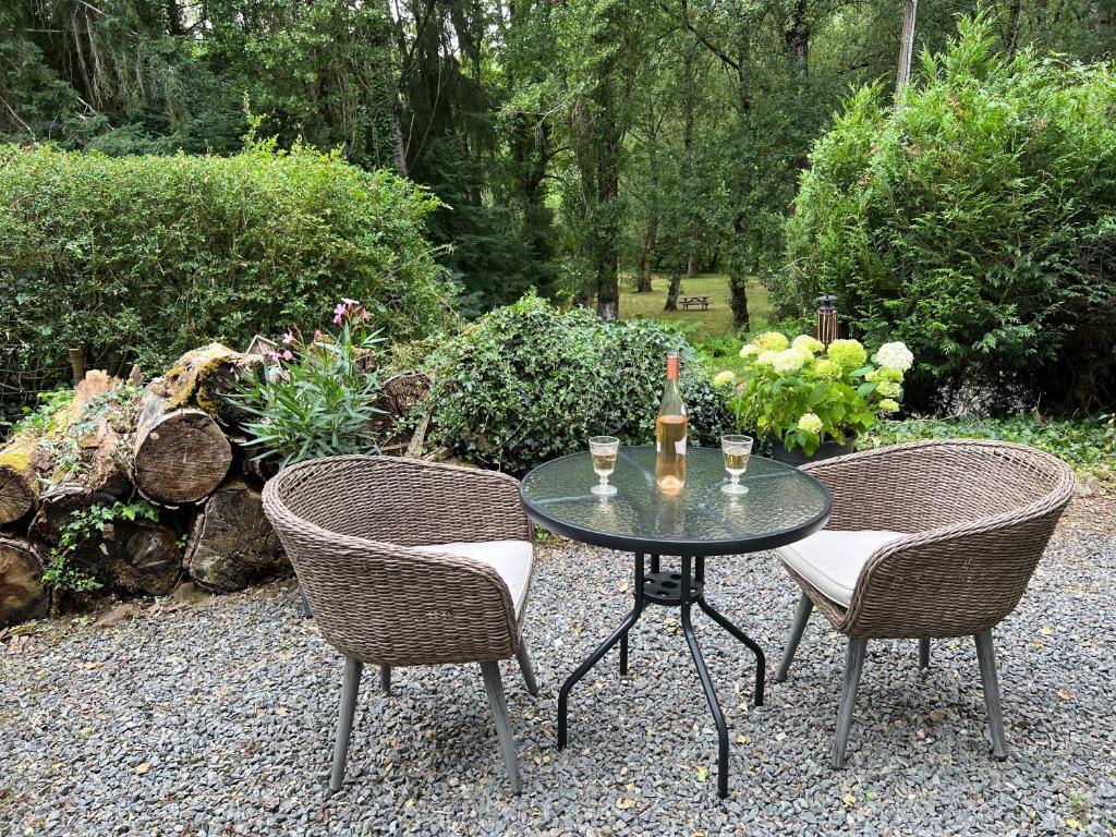 una mesa con 2 sillas y una botella de vino en Maple Tree Chambre d'hôtes, en Darnac