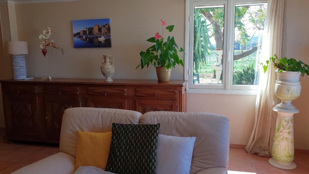 - un salon avec un canapé et une fenêtre dans l'établissement Rez de jardin, à Vescovato