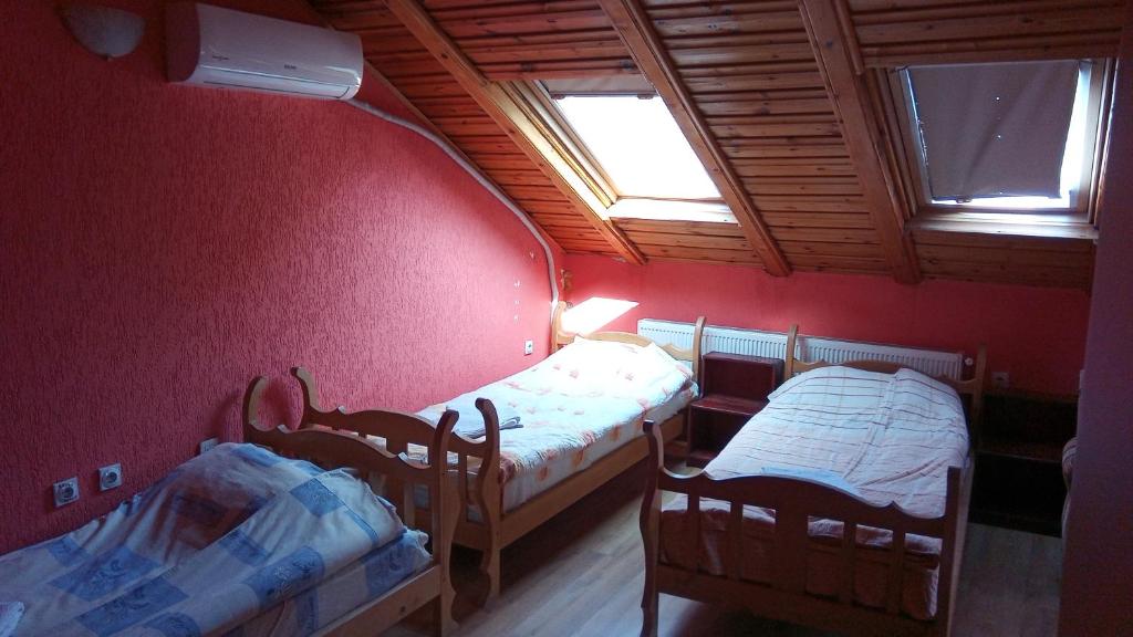 a small room with two beds and a window at Lovac in Štrpce