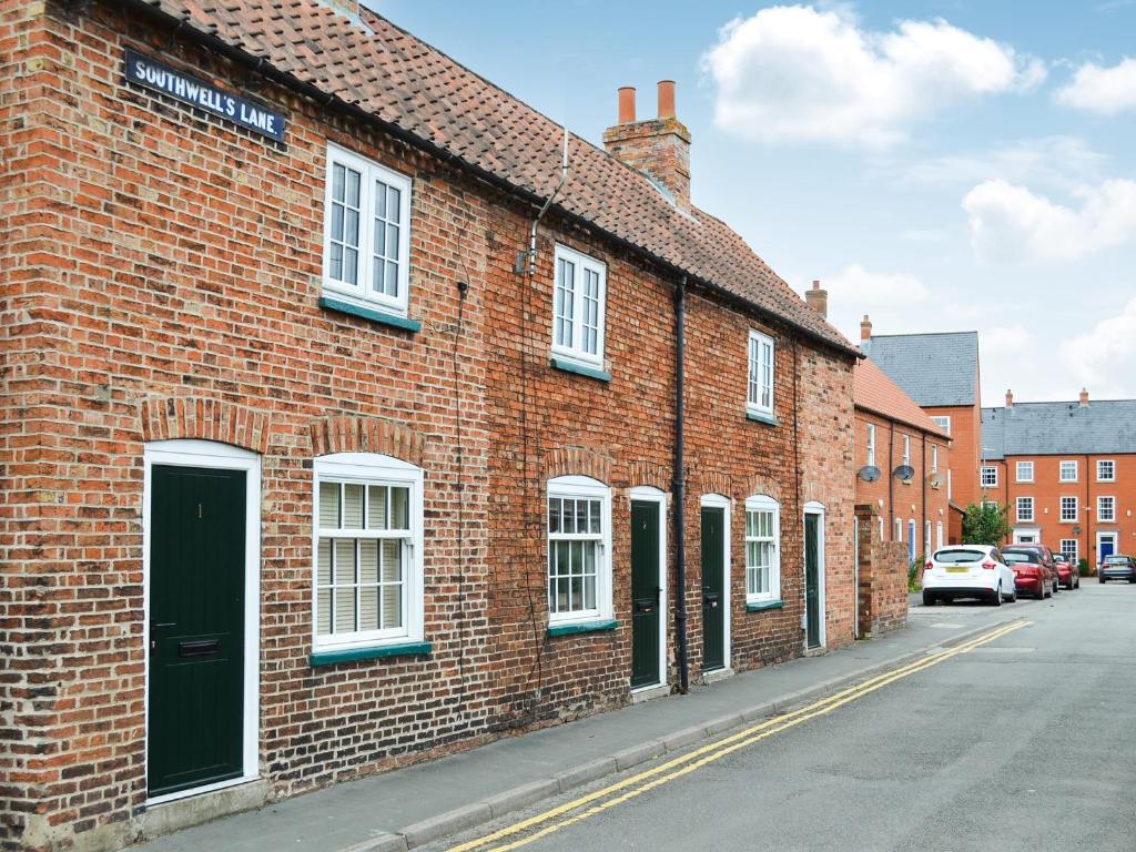 a brick building with a green door on a street at End Cottage in Horncastle