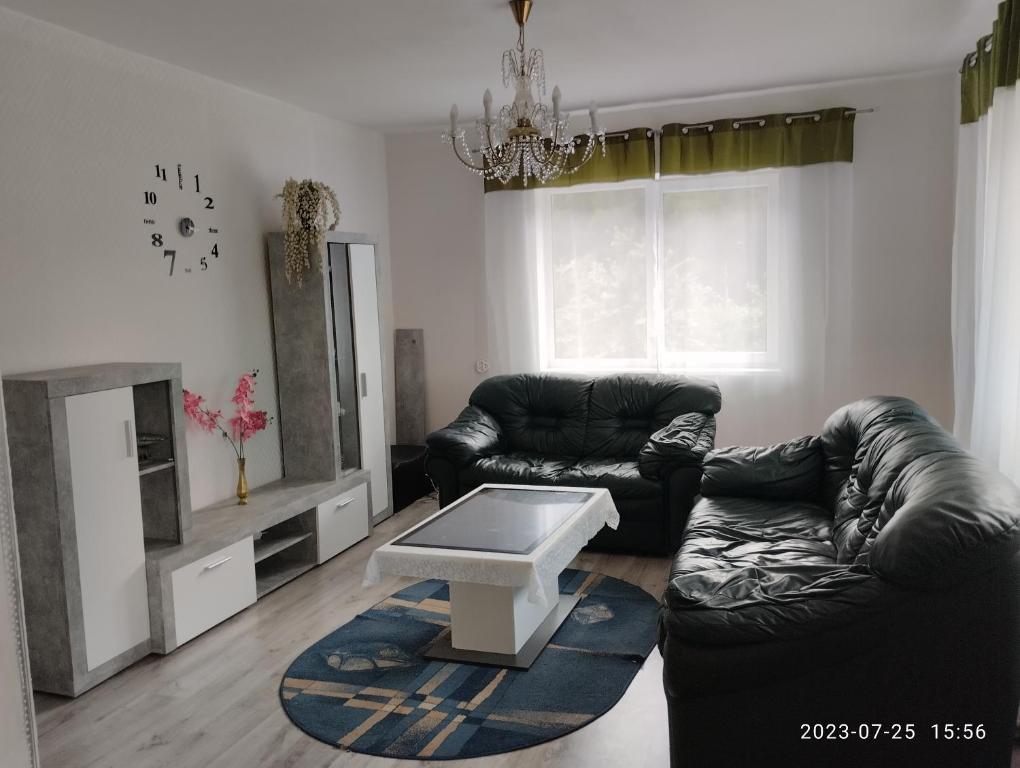 Sala de estar con 2 sofás de cuero y mesa de centro en Kambariu nuoma Tytuvenuose en Tytuvėnai