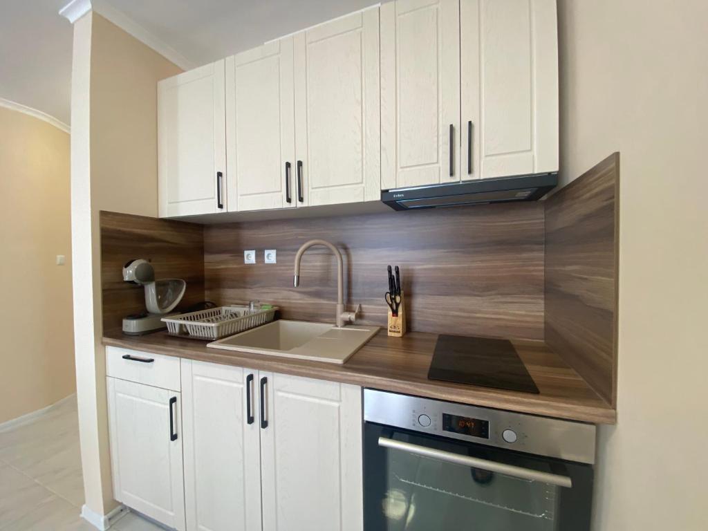 a kitchen with white cabinets and a sink at MARINA BAY 23 Sveti Vlas Beach in Sveti Vlas