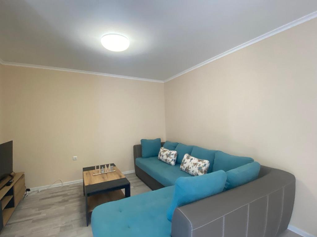a living room with a blue couch and a table at MARINA BAY 23 Sveti Vlas Beach in Sveti Vlas