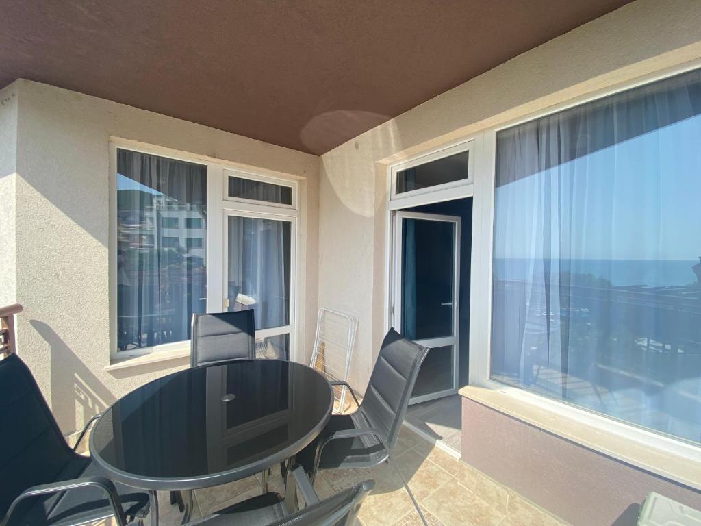 a dining room with a table and chairs and windows at MARINA BAY 23 Sveti Vlas Beach in Sveti Vlas