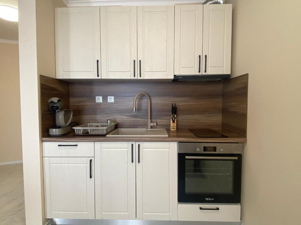 a kitchen with white cabinets and a sink at MARINA BAY 23 Sveti Vlas Beach in Sveti Vlas