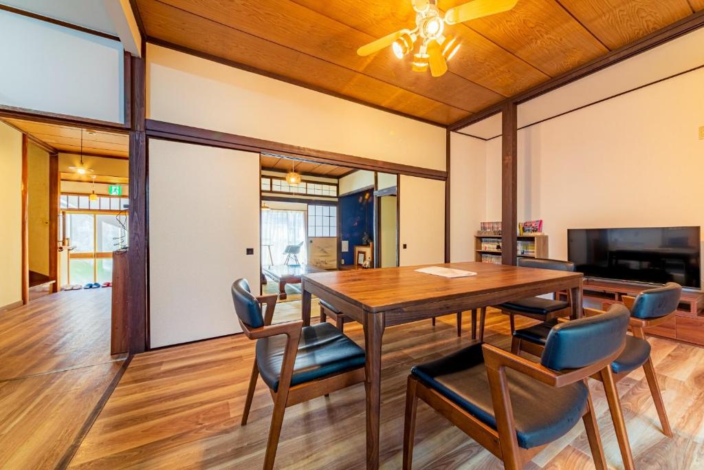 ein Esszimmer mit einem Holztisch und Stühlen in der Unterkunft CoCoSakura - Vacation STAY 94917v in Miyanoshita