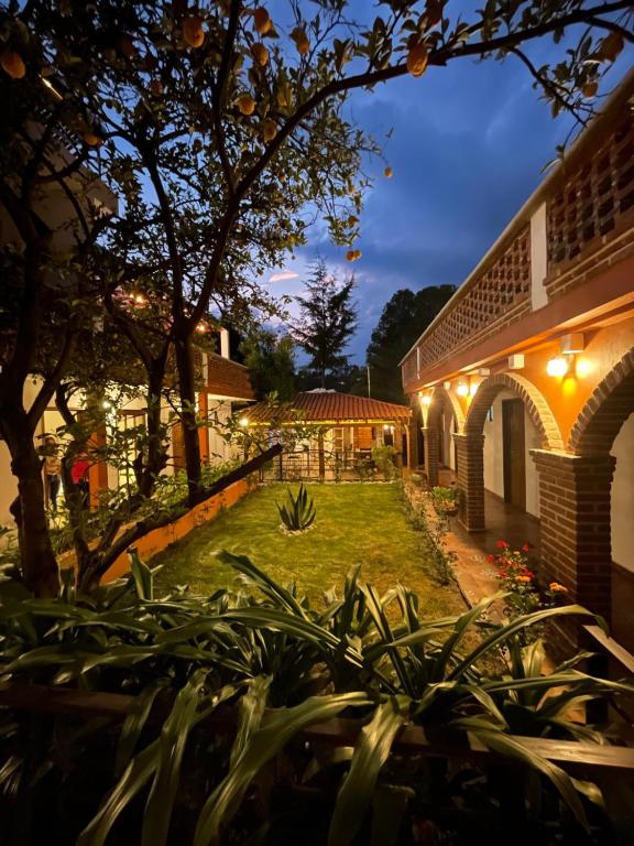 un patio de una casa por la noche con luces en Hotel RioMiel Tlaxcala, en Tlaxcala de Xicohténcatl
