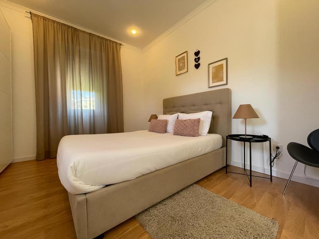 1 dormitorio con 1 cama blanca grande y ventana en Burgães II Apartment, en Oporto