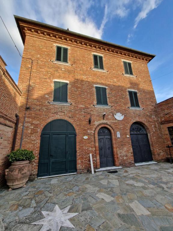 a brick building with three doors and a star at Le volte in Toscana in Bettolle