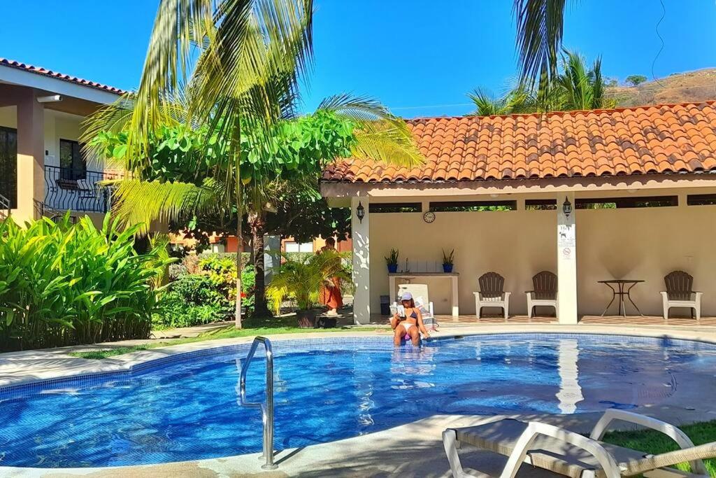a woman standing in a swimming pool next to a house at Jade Beach B apartamento 20 in Coco