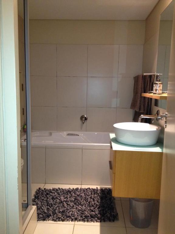 a bathroom with a bath tub and a sink at Umhlanga Gateway Apartments in Durban