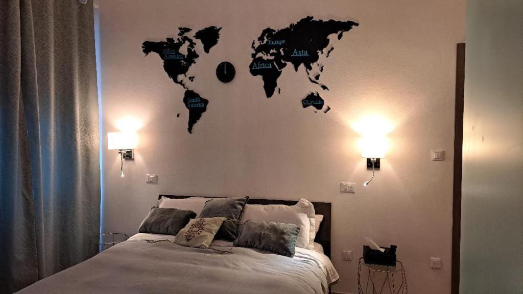 ein Schlafzimmer mit einem Bett mit einer Weltkarte an der Wand in der Unterkunft MIGU POINT Pisa in Pisa